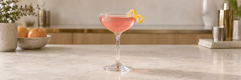 Rosa Cosmopolitan med sitronskall i et klart cocktailglass