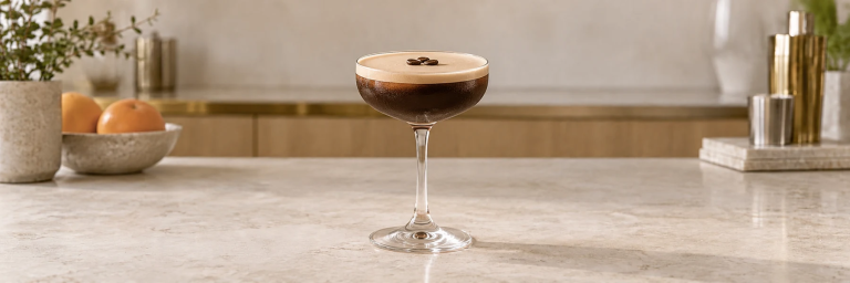 Espresso Martini i en coupe med kaffeskum og tre kaffebønner