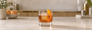 French Connection med gyllen cognac og amaretto over is, pyntet med appelsinskall