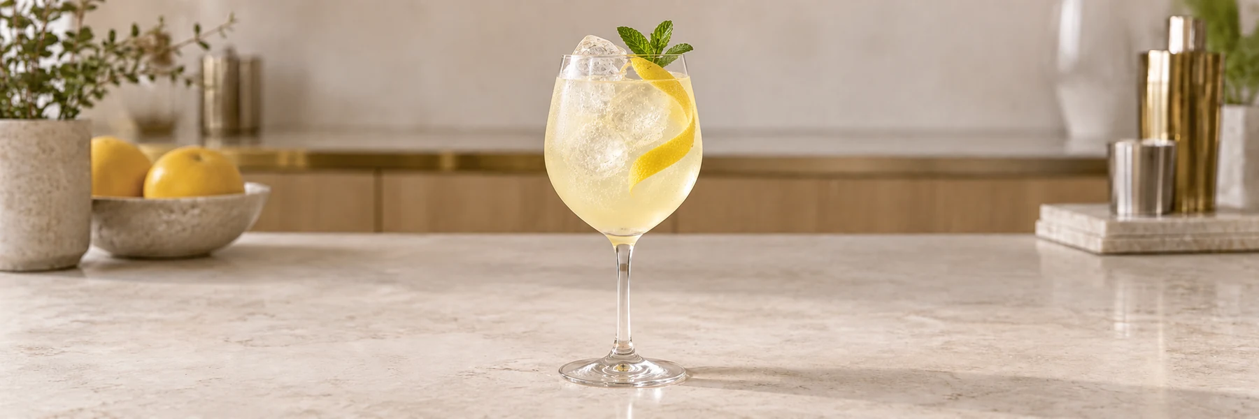Limoncello Spritz med is, sitronskall og mynte i et vinglass