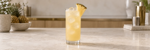 Malibu og ananas med is og en liten ananasskive i et høyt glass