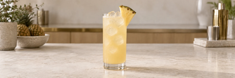 Malibu og ananas med is og en liten ananasskive i et høyt glass