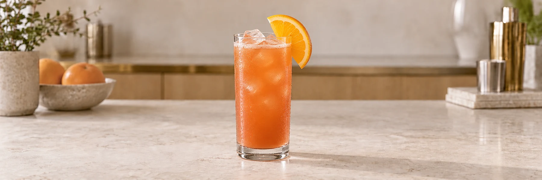 Rum Punch med is og appelsinskive i et høyt glass på en lys bardisk