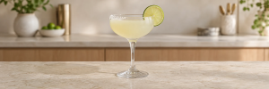 Margarita i coupeglass med lys limefarget drink, halv saltkant og limeskive