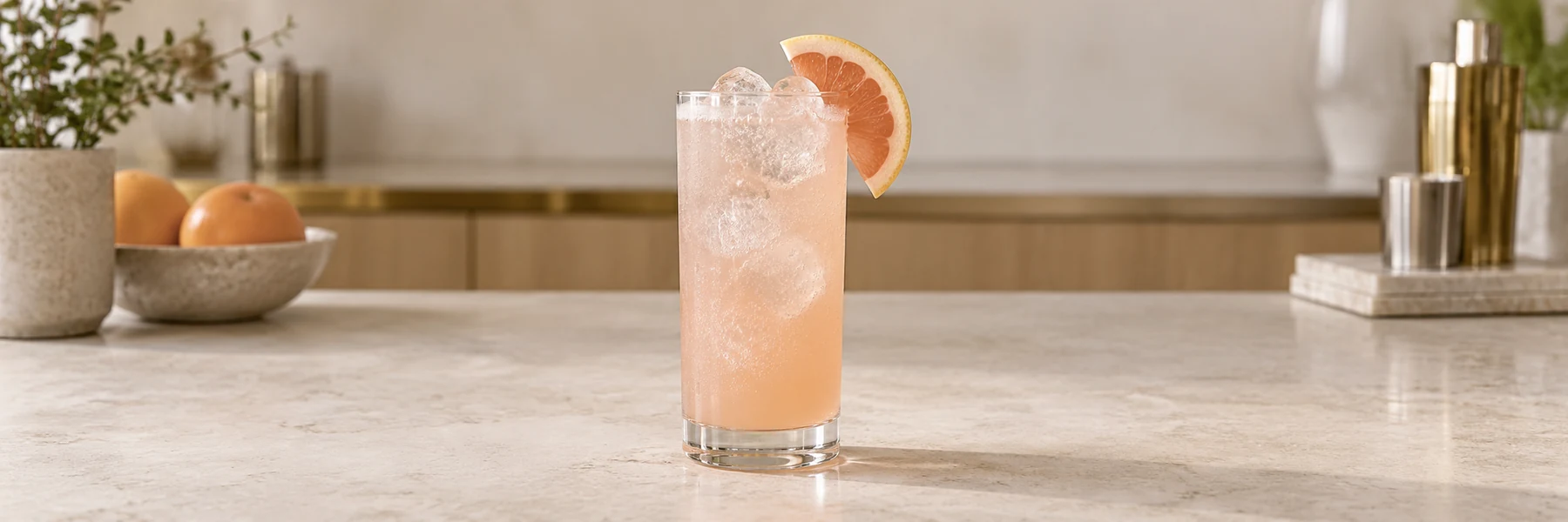 Paloma i høyt glass med is, svakt rosa grapefruktsoda og en grapefruktskive